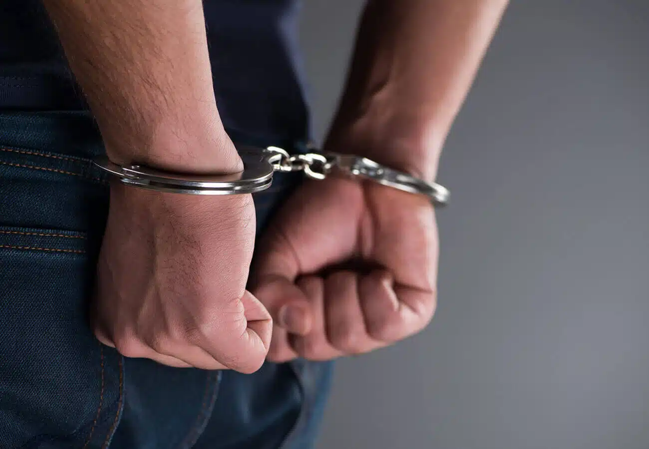 Man with his hands handcuffed in criminal concept